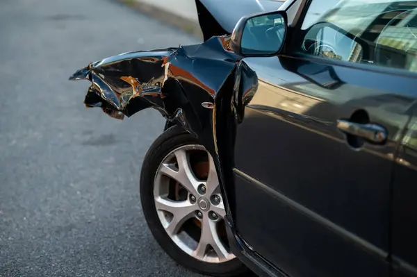 Çarpışmadan sonra görünen deformasyon, çizikler ve boya hasarı olan ezilmiş otomotiv panelinin detaylı görüntüsü.