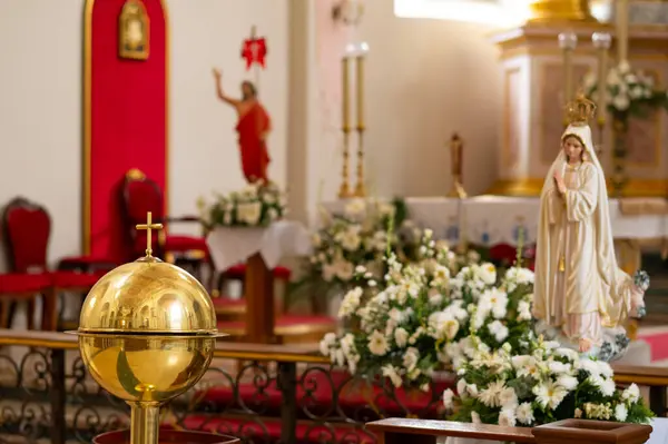 Katolik kilisesinin içinde vaftiz fontu ve Bakire Meryem heykeli var.