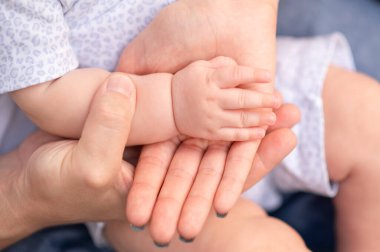 Çocuğun eli anne ve babanın avucunda, yakın plan.