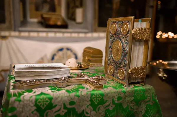 Ortodoks kilisesinde kilisenin masasındaki altın haç ve diğer kilise gereçleri vaftiz törenine hazırlanıyor.