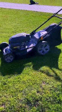 Çimlerin üzerinde çim biçme makinesi var