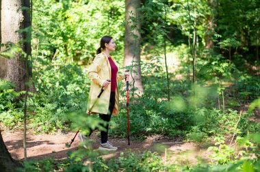 Aktif kadın orman yolunda kuzeye doğru yürüyor.