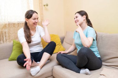 İki arkadaş kanepede oturmuş gülüyor. Komik bir şey tartışıyorlar. Kadın arkadaşlığı ve destek kavramı.