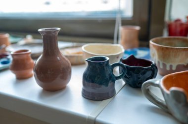 Çömlek atölyesinde renkli seramik bardaklar ve vazolar, yaratıcı sanatlar ayrıntıları.