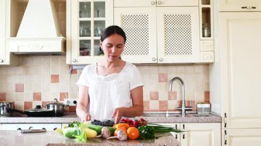 Kadın mutfakta taze sebze pişiriyor.