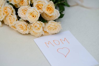 Çocuklar için Anneler Günü için el yapımı tebrik kartı. Üzerinde taze sarı bir gül buketi var. Sevgiyi, aileyi ve anneliği simgeliyor.