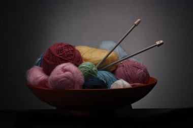 Örgü ipliği ve iğneli ahşap bir kase.