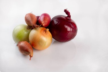 Beyaz arka planda üç farklı soğan çeşidi.