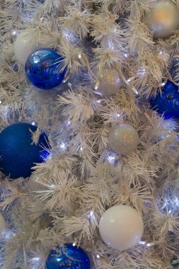 Yapay bir ağaçta asılı Noel süsleri