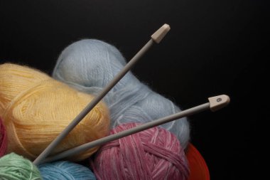 Bir demet renkli örgü ipliği ve örgü iğneleri..