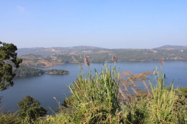 Umiam Gölü Meghalaya 'nın yeşil tepeleri arasında huzur içinde uzanır. Durgun suları gökyüzünü ve etrafındaki ağaçları yansıtır. Dağlık bölgelerde, sakin bir geri çekilme ve dokunulmamış doğanın çarpıcı bir görüntüsünü sunar..