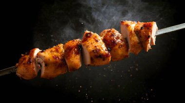 Siyah arka planda tavuk bacaklı barbekü..