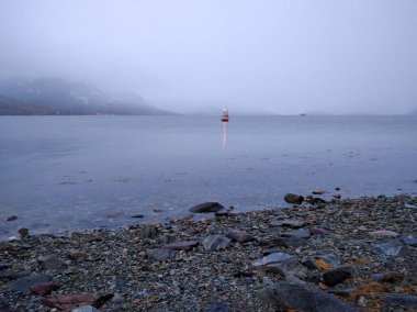 Kvaloya Norwegian Lake with a single lit ship in the distance in the winter months clipart