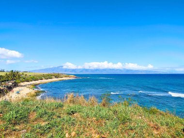 Hawaii, Ho 'okipa Sahili Manzarası' ndan okyanusun arkasındaki bir adaya bakan kaplumbağa kumsalına bakıyor.