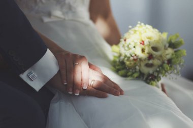 Düğün çifti el ele tutuşuyor.
