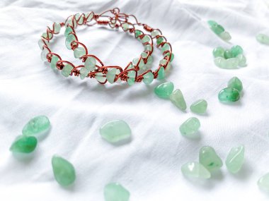 Beyaz arka planda yeşil boncuklu el yapımı bilezik..