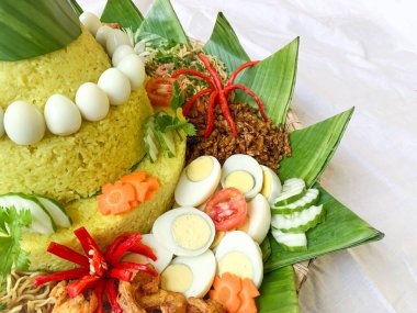 Nasi Tumpeng adında geleneksel bir yemek, etrafında çeşitli mezeler olan sarı pirinç konisi. Genellikle Endonezya 'da doğum günlerini, yıldönümlerini ve resmi etkinlikleri kutlamak için servis edilir..