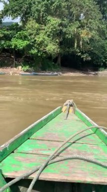 Taşıma olarak ahşap bir tekneyle nehri geçmek. Sakin bir köye yolculuk. Kırsal turizm kavramı.
