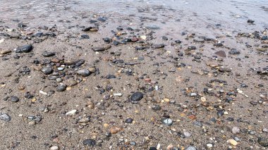 Kumsalda çakıl taşları