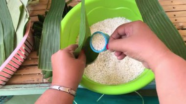 Muz yaprağıyla sarılmış glutinöz pirinç işlemi. Lupis Endonezya geleneksel pirinç keki yapmak için..