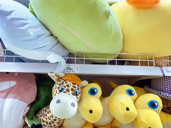 Hayvan karakterli yastıklar oyuncak bebekleri raflara koyuyor. Güney Sulawesi, Endonezya - 10 Kasım 2024.