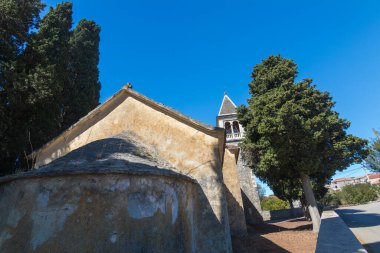 Bereketli mavi gökyüzünün altında, dingin, antik bir kilise. Huzur ve tarihi bir cazibe barındırıyor..