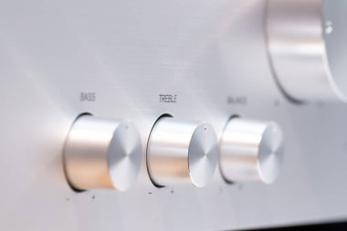 Ses yükseltici kontrol düğmelerinin baslar, trible ve ses dengesi için detaylı görüntüsü. Metalik yüzey, ses işleme ekipmanlarının kalitesini yansıtan hassas yerleşim düzenini tamamlıyor..