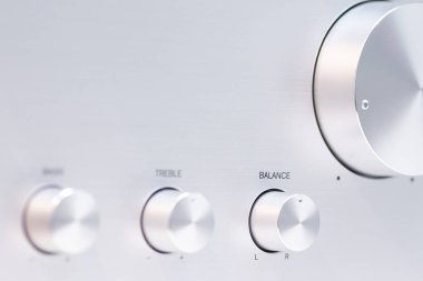 Ses yükseltici kontrol düğmelerinin baslar, trible ve ses dengesi için detaylı görüntüsü. Metalik yüzey, ses işleme ekipmanlarının kalitesini yansıtan hassas yerleşim düzenini tamamlıyor..