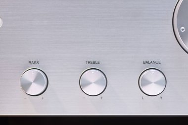 Ses yükseltici kontrol düğmelerinin baslar, trible ve ses dengesi için detaylı görüntüsü. Metalik yüzey, ses işleme ekipmanlarının kalitesini yansıtan hassas yerleşim düzenini tamamlıyor..
