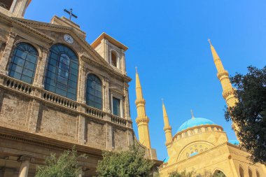 Yanyana duran bir cami ve kilise manzarası, karşıt mimari ve kültürel öneme sahip, göz alıcı mavi bir gökyüzü altında ele geçirilmiş..