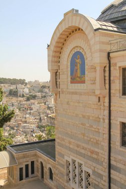 Karmaşık dini sanat eserleri, dekoratif elementler ve geometrik desenler içeren güzel bir taş kilise. Mimari, berrak mavi gökyüzünün arka planına karşı huzurlu bir atmosfer taşır..