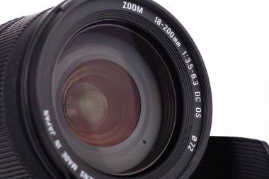 Kamera merceğinin karmaşık doğasını gösteren yakın plan fotoğraf, mühendislik ve yüksek optik kalitesini gösteriyor, beyaz bir zemin üzerine kurulu, fotoğrafçılık veya teknoloji bağlamları için ideal..