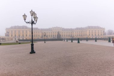 Görkemli tarihi bir saray yumuşak bir sabah sisi ile kaplanmış, büyüleyici ve karmaşık geleneksel lamba direkleriyle birlikte mimari zarafet ve dingin bir ortam sergiliyor..