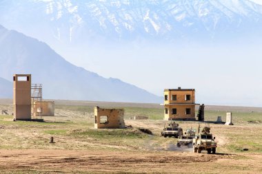 Geniş bir çöl arazisinde ilerleyen askeri araçlara geniş bir bakış açısı, taktiksel operasyonları ve askeri hazırlıkları ön plana çıkarırken aynı zamanda çevredeki geniş vahşi doğayı ve dağlık zemini gözler önüne seriyor..