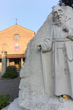 Görüntüde demir kapılı tuğla bir kilise ve sakin bir avluda güneş ışığıyla yıkanmış bir haç görülüyor. Mimari ayrıntıları onu dini mirasın ilgi çekici bir temsilcisi yapıyor..