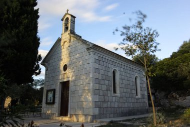 Bereketli yeşil ve yumuşak güneş ışığıyla huzurlu bir doğal ortamda, güzel taştan bir kilise. Açık hava ortamında mimari cazibe ve maneviyatı sergiliyor..