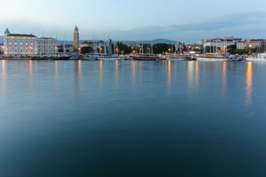Split 'in deniz manzarası, tarihi işaretler, palmiye çizgili gezinti alanı ve berrak mavi gökyüzünün altındaki manzaralı dağ manzarası..
