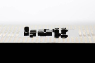 Gelişmiş teknoloji uygulamalarında karmaşık elektronik tasarım ilkeleri ve yüzey düzeyinde mikromühendislik gösteren bir mikroçip üzerinde detaylı bileşenleri gösteren yakın çekim görüntüsü.