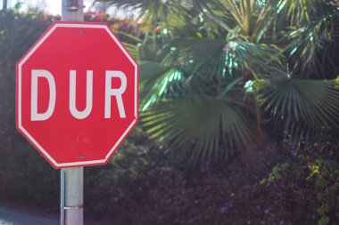 Yeşil park ayarı içinde Türk metni bulunan kırmızı bir sekizgen trafik dur işareti.