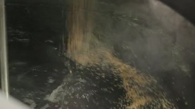 Bira fabrikasında bira tankını dolduran arpa tohumu.