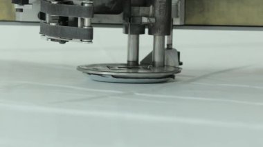 Dikiş makinesinin iğnesi ve ayağı kumaşı delip geçer.