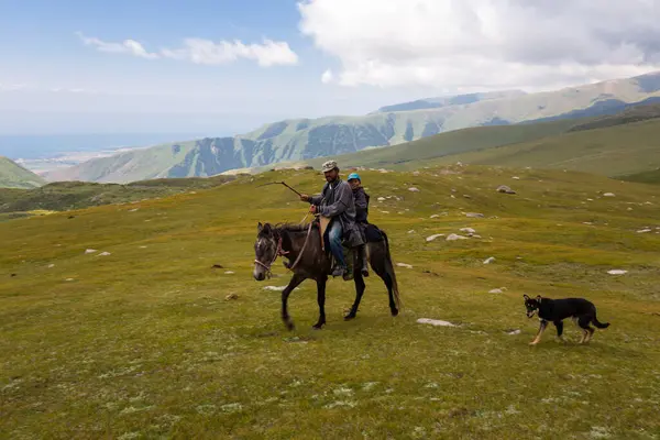 CHOLPON ATA, KYRGYZSTAN - 03 Temmuz 2022: Kırgızistan, Orta Asya 'daki Tianshan Dağları' nda ata binen çobanın görüntüsü