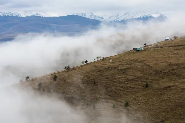 Rusya 'nın Karachay-Çerkesya Cumhuriyeti' ndeki Kafkas dağlarının panoramik manzarası bulutlarla kaplıdır.