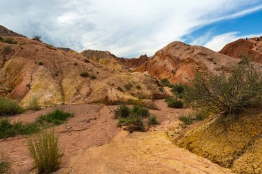 Tian Shan dağlarındaki Terskey Ala-Too dağ sırasındaki Peri Masalı Kanyonu 'ndaki (Kanyon Skazka) kızıl Mars kayaları arasında yürüyüş, Kırgızistan' daki yaz yolculuğu.