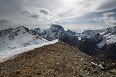 Karachay-Çerkesya Cumhuriyeti, Dombay 'daki yüksek karlı dağların manzarası, Rusya' nın bulutlu sonbahar günü. Seyahat, macera, özgürlük kavramı