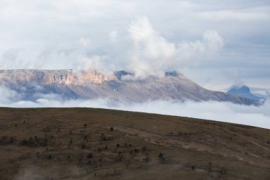 Rusya 'nın Karachay-Çerkesya Cumhuriyeti' nde Kafkasya dağlarının sonbahar manzarası bulutlarla kaplıdır. Seyahat, macera ve yolculuk