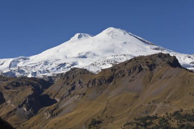 Rusya 'nın Kabardino-Balkaria kentindeki Cheget Dağı' ndan Elbrus Dağı 'nın panoramik manzarası. Karla kaplı, iki tepeli, hareketsiz volkan