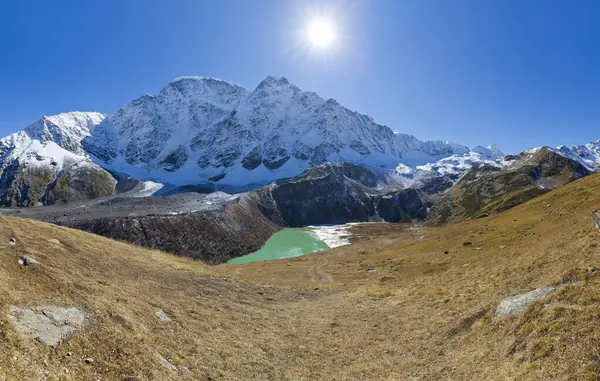Rusya 'nın Kabardino-Balkaria eyaletindeki Kafkasya dağlarında karlı tepelerin panoramik manzarası ve turkuaz gölü Donguz Orun Kel. İskoçya 'da sonbahar gezisi