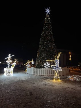 Birstonas, Litvanya 'da Noel ağacı. Işıklarla süslenmiş ve üzerinde yıldız olan uzun, aydınlık bir Noel ağacı açık hava ortamında duruyor.. 