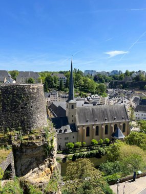 Lüksemburg 'un panoramik manzarasında yüksek kulesi, geleneksel Avrupa mimarisi ve yemyeşil verimli bir kilisesi vardır. Taştan duvarları olan tarihi kaleler. 